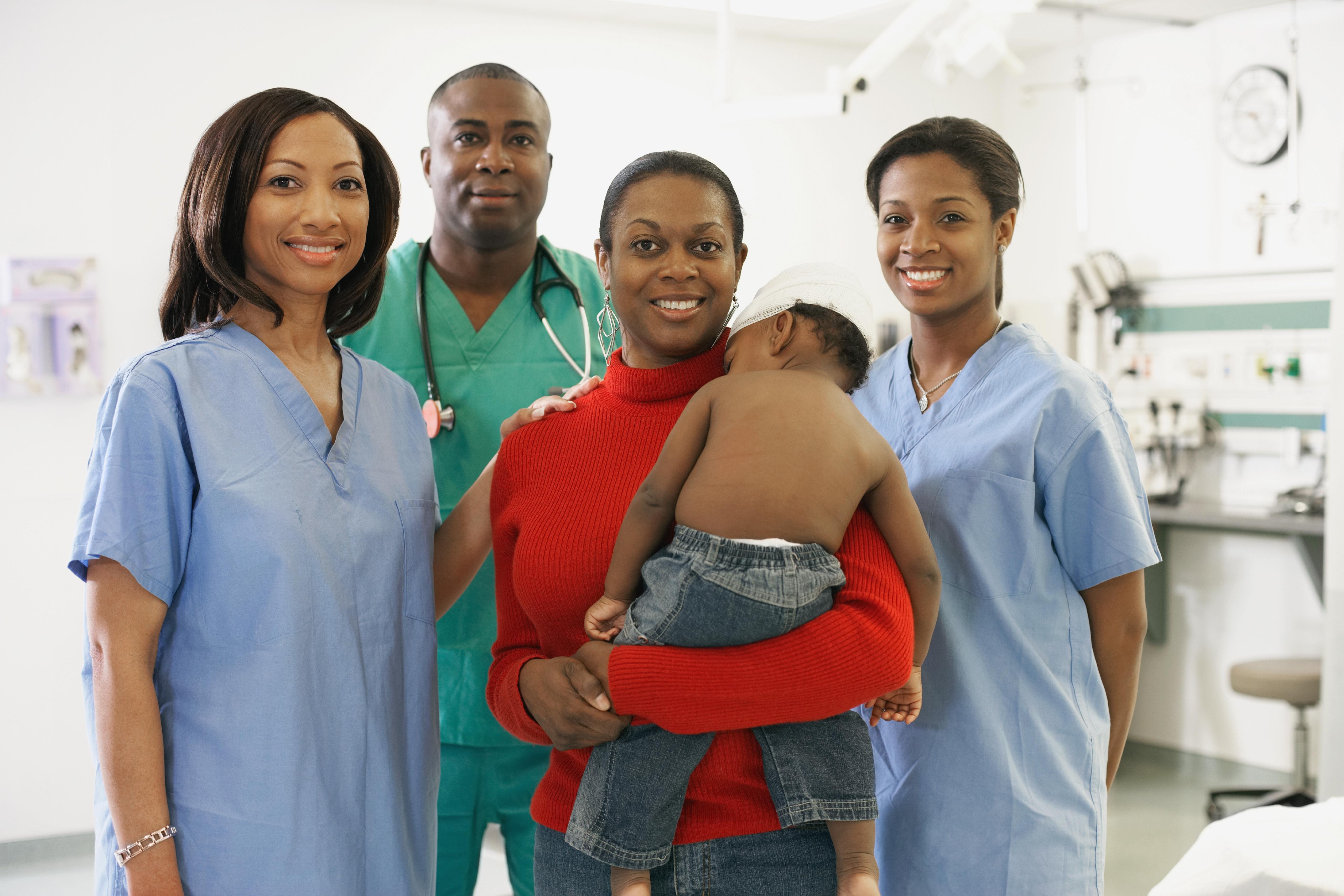 African American mother and baby surrounded by medical professionals