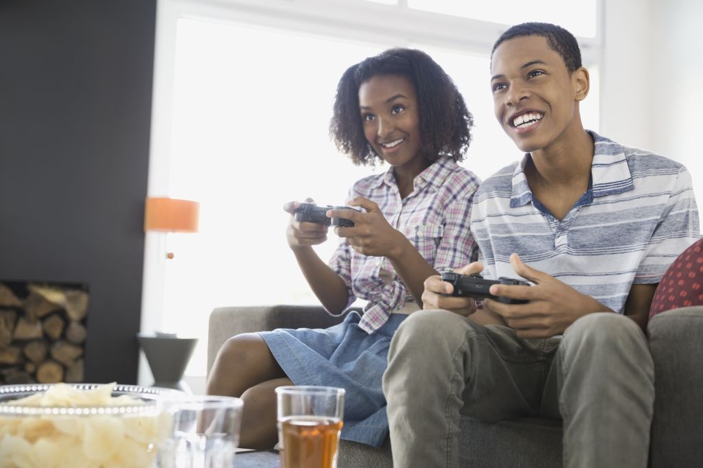 Siblings playing video games at home