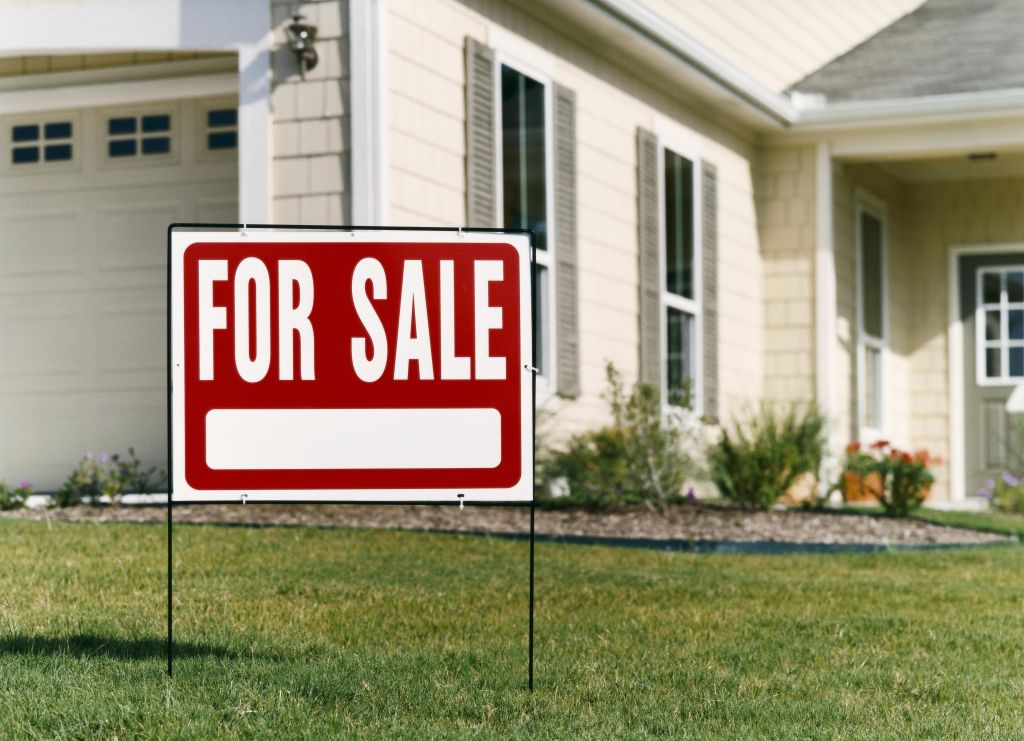 For Sale Sign on a Lawn in Front of a House