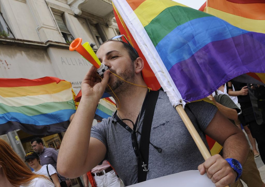 A demonstrator blows a horn as he takes