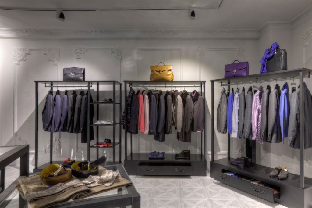 Suits and shoes on racks in clothing store for men