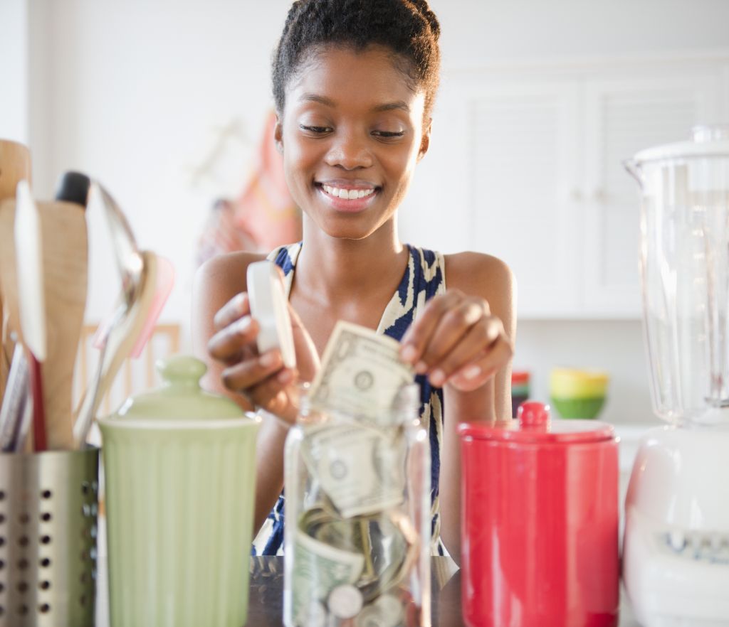 Black woman taking money out of jar