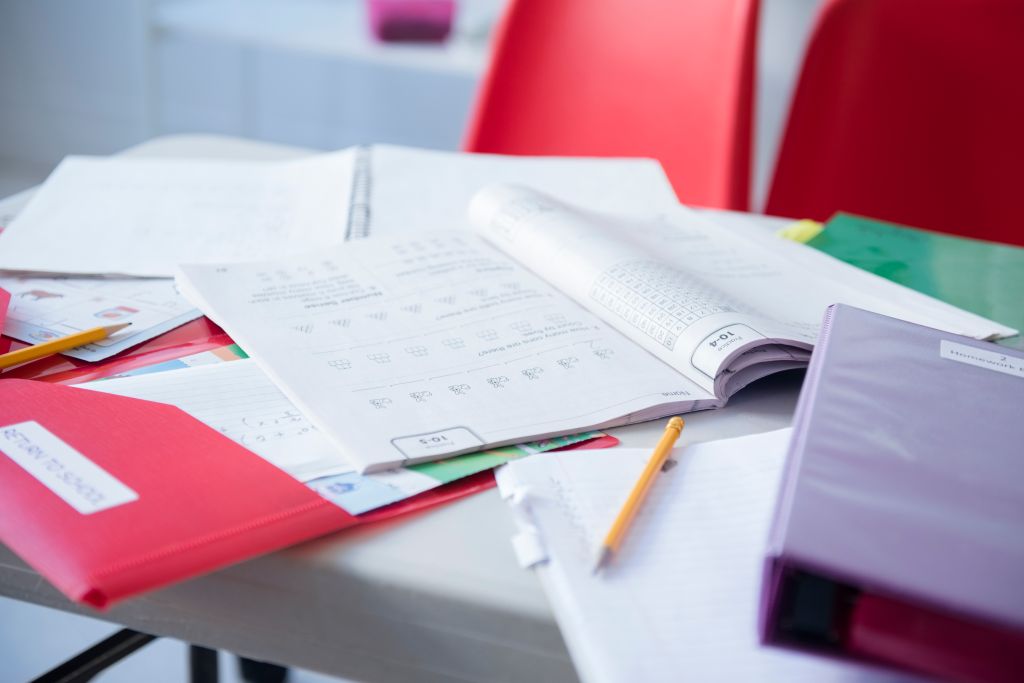 Workbook and folder on desk in classroom