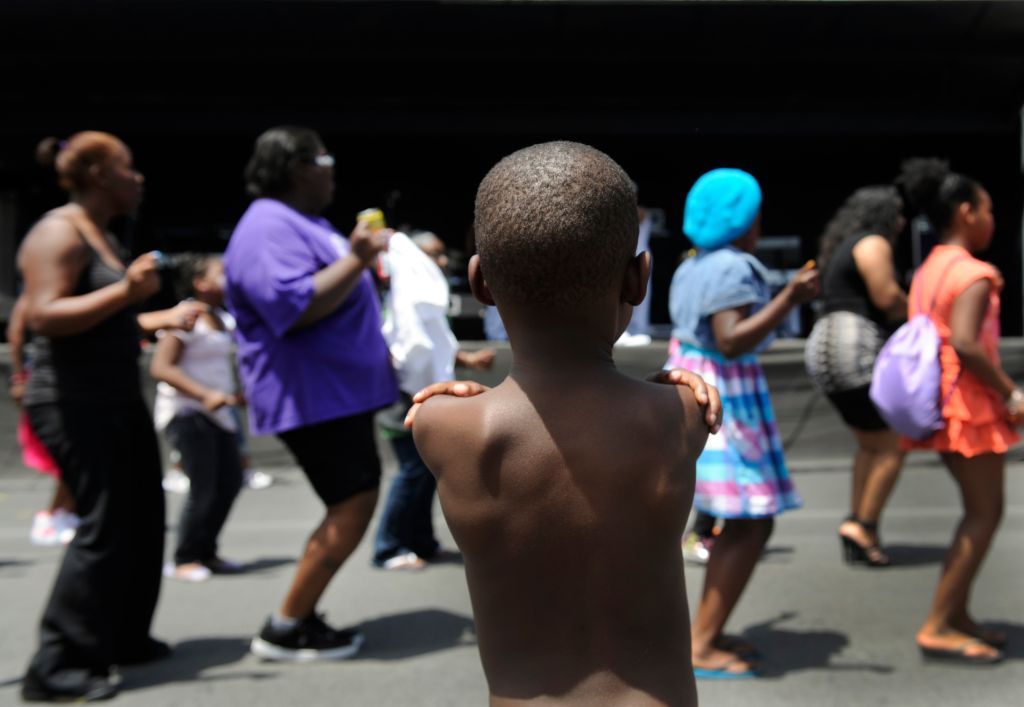 LaTrone Taylor-Witherspoon, 4, watches as a crowd gathers in front of the main stage at the festival to do the Cupid Shuffle. The Friends of Blair Caldwell African American Research Library Foundation hosts the 2011 Denver Juneteenth Celebration: We Defin
