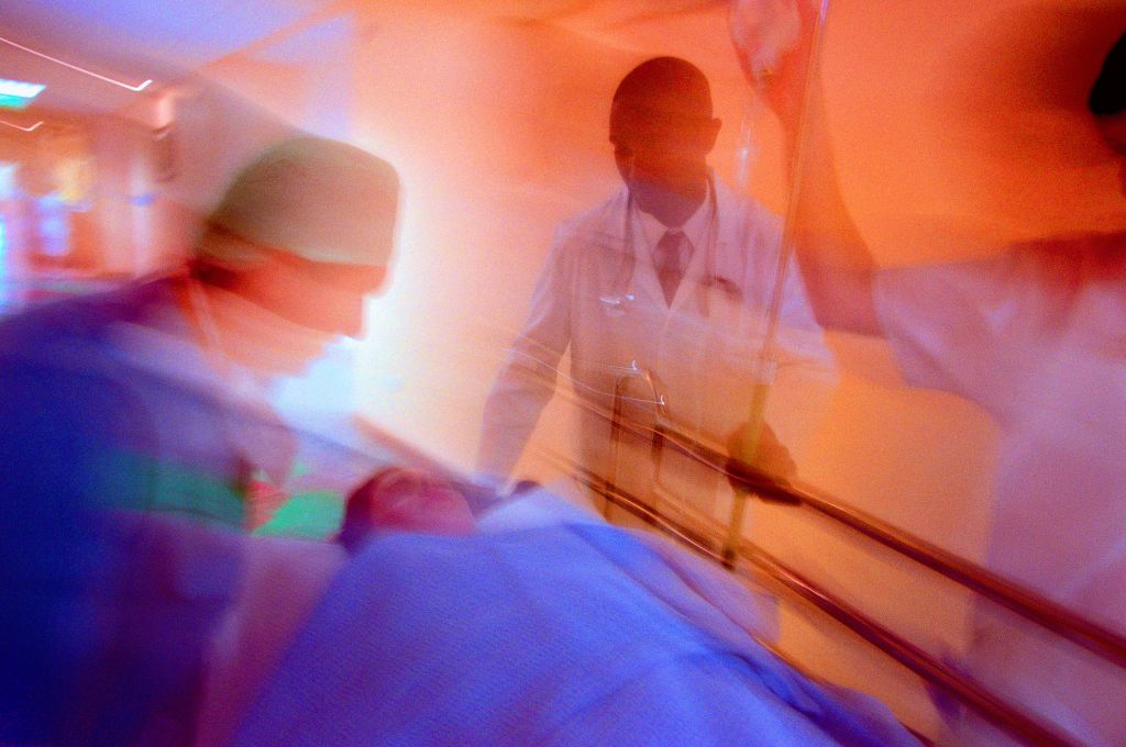 portrait of doctors and a nurse wheeling a patient on a gurney