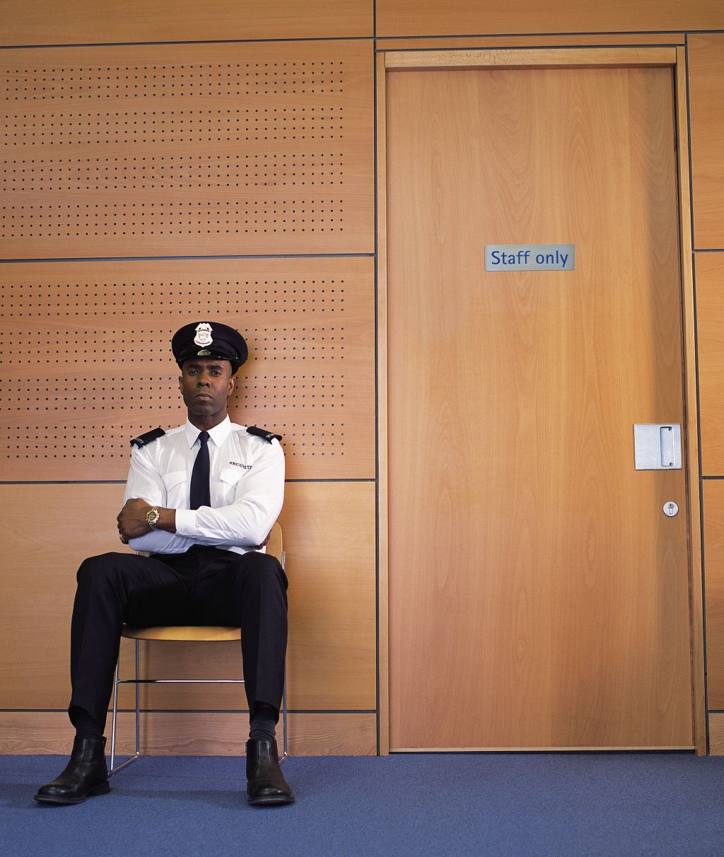 Security guard sitting by office door
