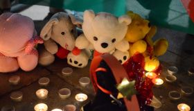 People leave assorted toys and candles in the memory of the...