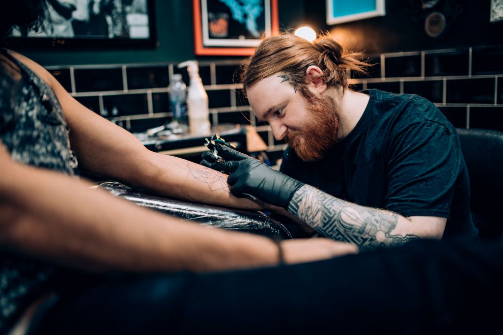 Tattooing a Man's Arm