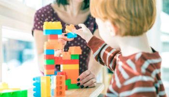 Mother and Baby Boy Playing with Colorful Blocks