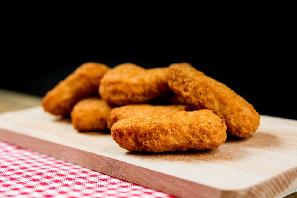 Close-Up Of Chicken Nuggets On Table Against Black Background