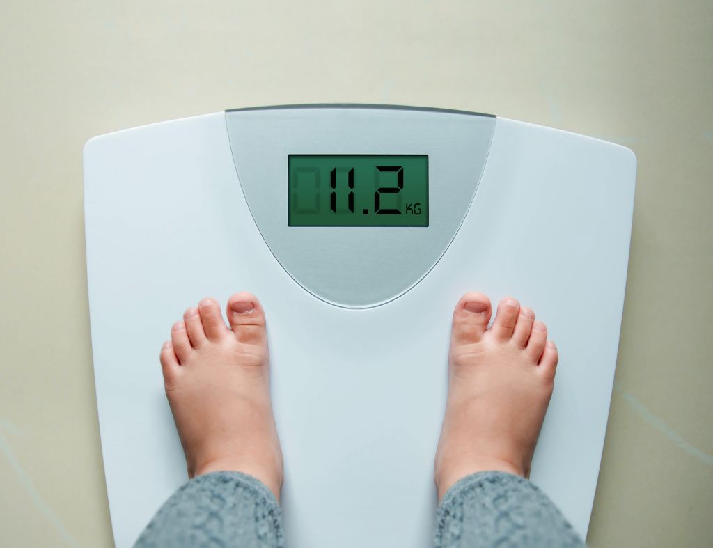 Low Section Of Child Standing On Weight Scale