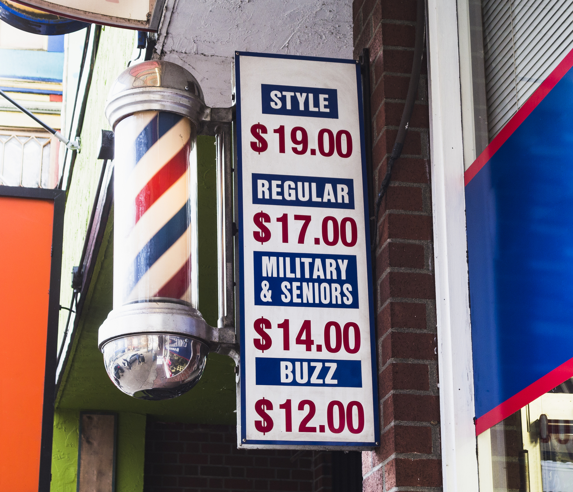barber pole and sign in front of barber shop