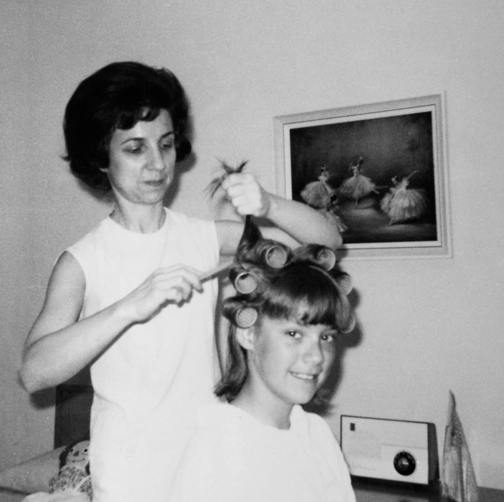 Mother helps 16 year old daughter get ready for date, ca. 1970