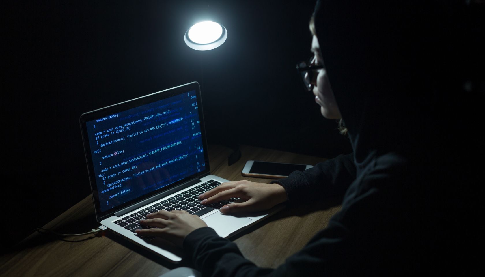 Young hooded woman hacker doing cyber attack