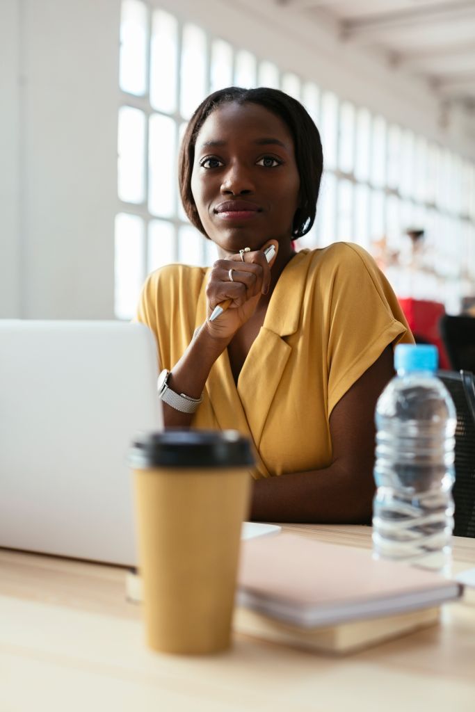 Portrait of confident young woman at desk in office