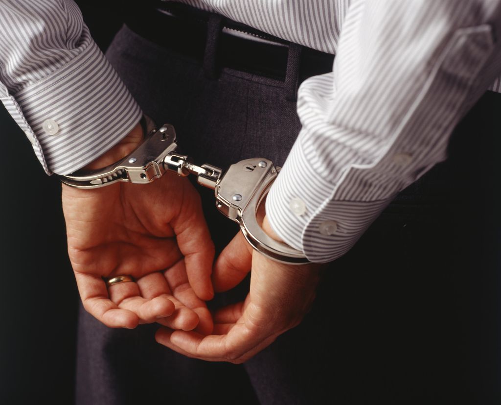 Man in handcuffs, rear view, mid section, (Close-up)