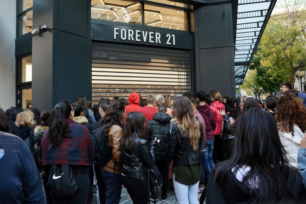 People are seen standing outside forever 21 shop as they...