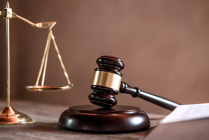 Close-Up Of Gavel And Weight Scale On Table