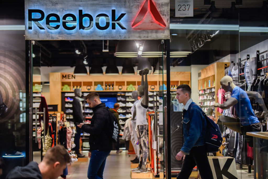 People are seen next to the Reebok shop...