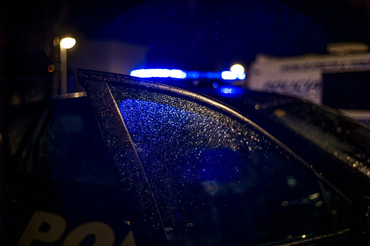 Spain, Madrid, rain falling on the window of police car at night