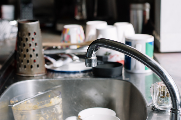 Close-Up Of Faucet And Utensils In Kitchen At Home