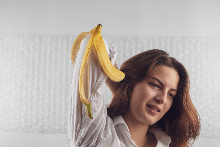 Young Woman Holding Banana Peel