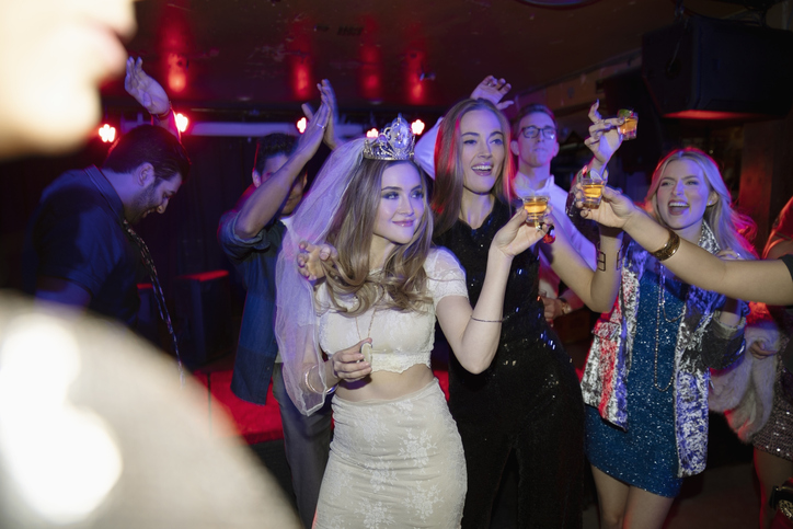 Bachelorette and friends dancing and drinking in nightclub