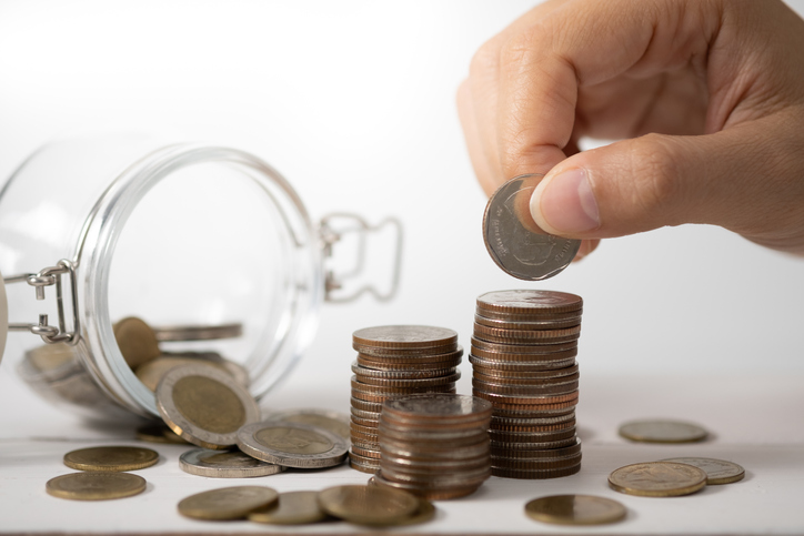 Cropped Hand Stacking Coins On Table