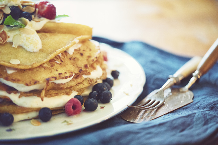 Lovingly stacked homemade pancakes pie with cream and fruits
