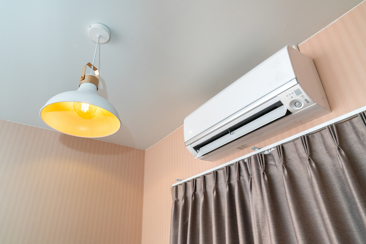 Low Angle View Of Air Conditioner By Lighting Equipment At Home
