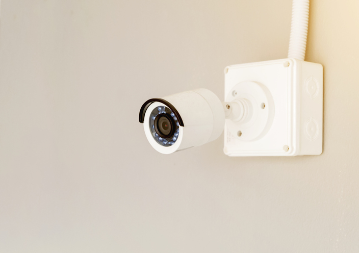 Security Camera Attached On White Wall