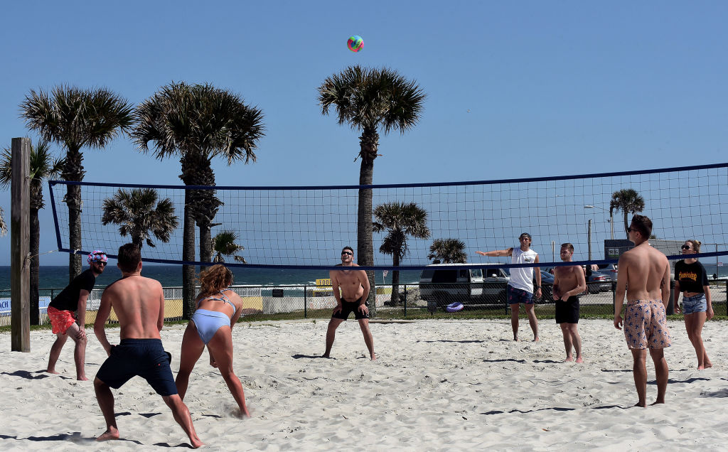 Spring breakers play volleyball during a spring break at...