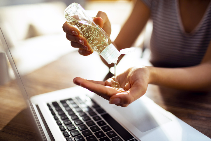 Young woman using a hand sanitizer