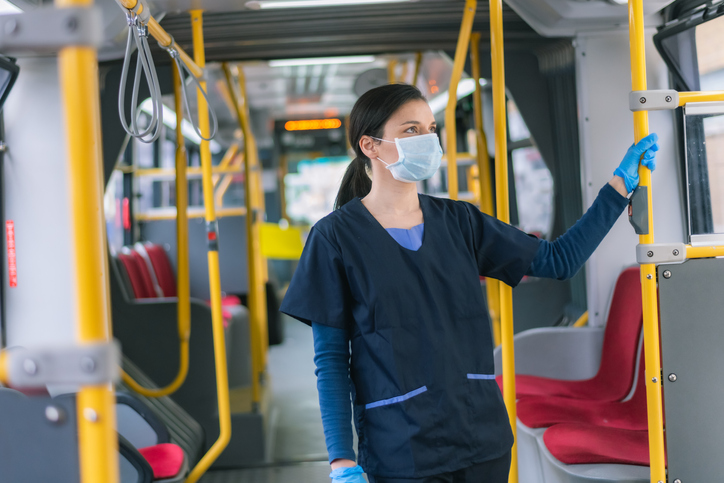 A nurse rides the bus alone on the way to her day shift at the hospital