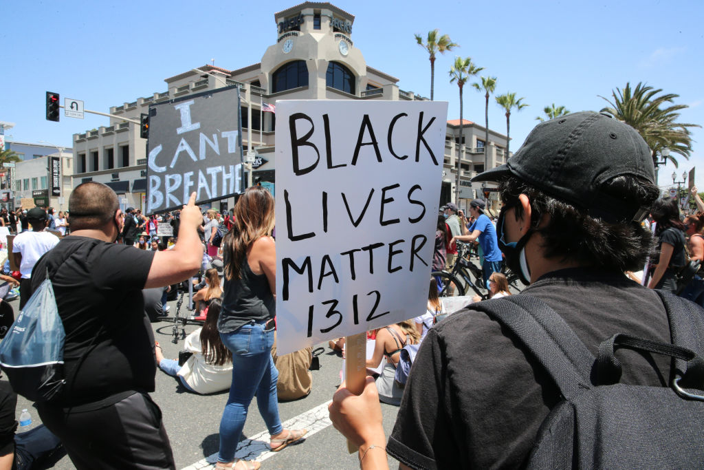 Protesters hold placards during the demonstration. The death...