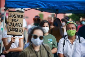 A protester holds a placard that says Justice for Vauhxx...