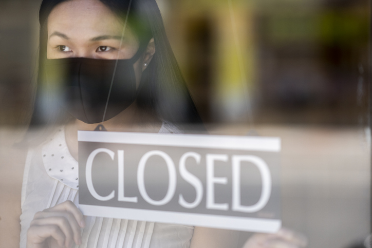 Female business owner closing her store and promoting online shopping while being closed due to COVID19.