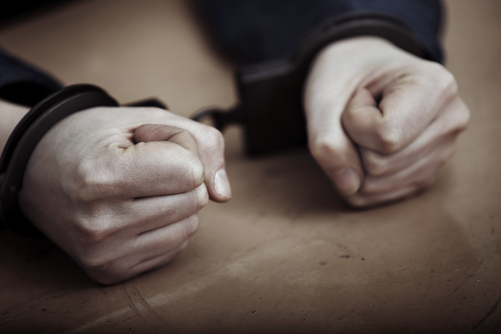Hands of arrested man in handcuffs