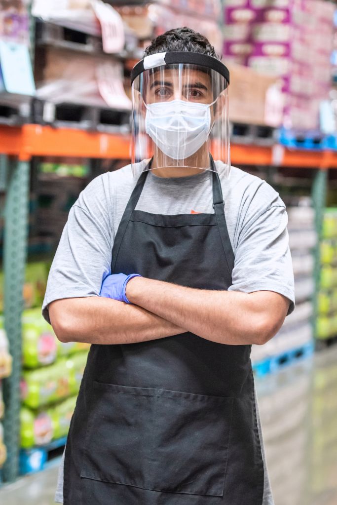 Megastore employee wearing a protective face mask and a face shield