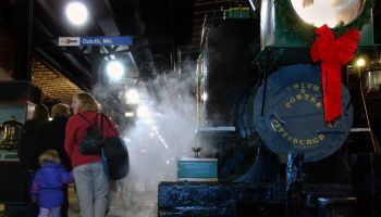 Duluth,Mn.,Fri.,Nov. 26, 2004--Passengers aboard the Polar Express which travelled from Fitger's Inn to the Lake Superior Railraod Museum, walk past a steamy Minnetonka (the first engine on the Northern Pacific Line), on their way to a reading of Chris Va