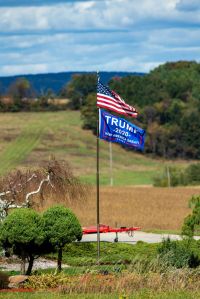 A Trump 2020 re-election flag flies below an Amrican flag in...