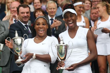 Venus and Serena pose with the winner's trophies at the 2016 Wimbledon Championships