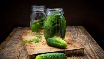 Pickled gherkins in jar with mustard seeds and dill