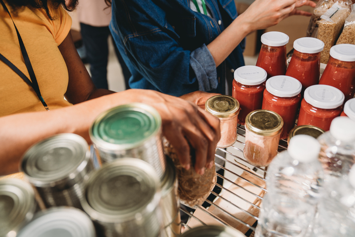 Two women are arranging food and drinks on the shelves - Close up shot