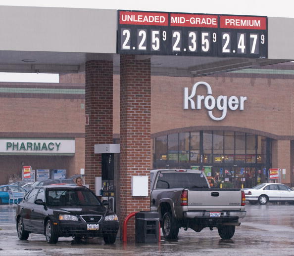 Customers pump gasoline at a Kroger gasoline station in the