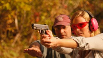 Woman Getting Instructed At Shooting Range With Handgun