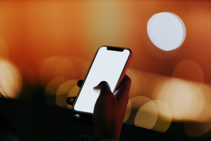 Close-up of using smartphone at night