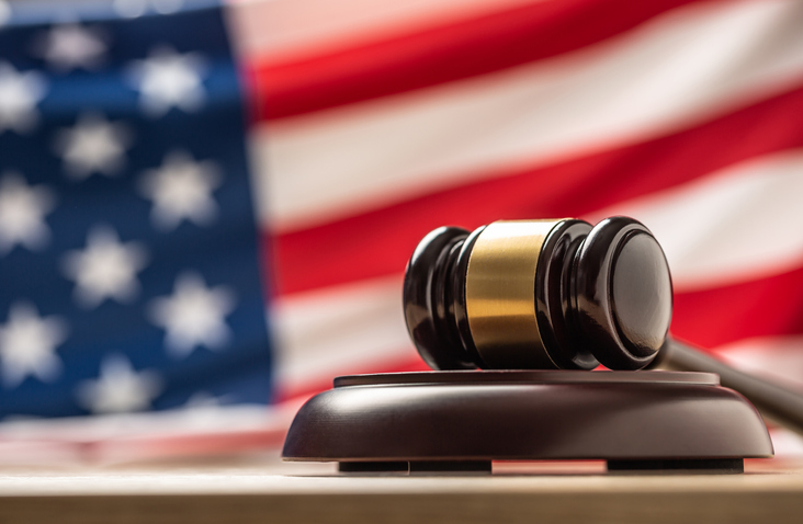 Judges wooden hammer in front USA flag.