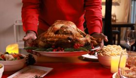 Close up hand holding Baked chicken serve on luxury dining table, Christmas eve celebration or party preparation concept ,roasted Chicken. Christmas and New Year food concept