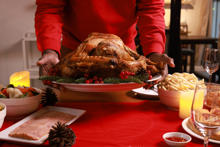 Close up hand holding Baked chicken serve on luxury dining table, Christmas eve celebration or party preparation concept ,roasted Chicken. Christmas and New Year food concept